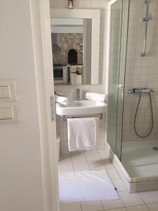 a white bathroom with a sink and a shower at VILLA "Mezraya" à 500 m de la plage - DJERBA in Mezraya