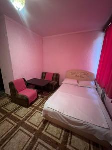 a bedroom with a bed and chairs and a table at Touristic House KAEL in Musalerr +9 photos