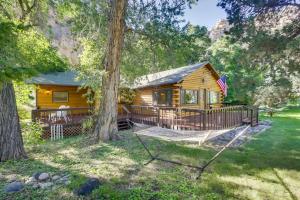 a log cabin in the woods with a swing at Creekside Ten Sleep Vacation Rental and Deck and Grill in Ten Sleep