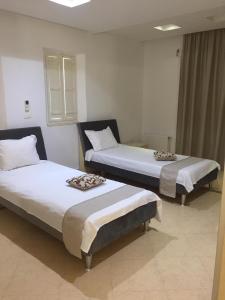 two beds sitting in a room with at VILLA "Mezraya" à 500 m de la plage - DJERBA in Mezraya