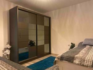 a bedroom with two beds and a large glass cabinet at Apartman “ROSE” in Martin