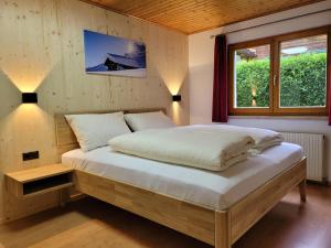Schlafzimmer mit einem großen Bett und einem Fenster in der Unterkunft Alpenglück Montafon in Sankt Gallenkirch