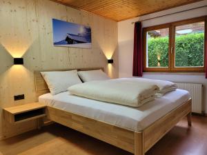 a bedroom with a large bed with a window at Alpenglück Montafon in Sankt Gallenkirch +46 photos