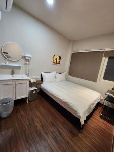 Rúm í herbergi á SWF hotel 淡水新五福旅館-新北市旅館編號067