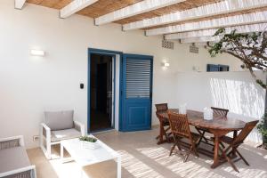 comedor con mesa y sillas y puerta azul en Villa Blumarine sul mare en San Vito lo Capo