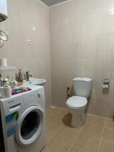 uma casa de banho com um WC e uma máquina de lavar roupa em Aile Dağ evi em Arsin