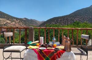 a table with food on a balcony with mountains at Atlas Imsker in Marrakesh