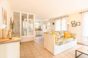 a living room with a couch and a kitchen at New Charmante maison proche océan in Biscarrosse