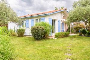 una casa blanca con un patio delante en New Charmante maison proche océan en Biscarrosse