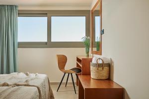 1 dormitorio con cama, escritorio y silla en Letsos Hotel, en Alykes