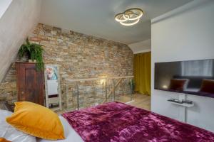 um quarto com uma parede de tijolos e uma cama em Le Baroque clim et sauna em Annecy