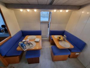 Kalkara的住宿－Riti Yacht，小房间设有两张桌子和一张蓝色的沙发