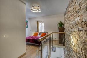 a room with a bed and a stone wall at Passage des bains in Annecy