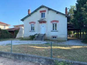 una vieja casa blanca con una puerta delante de ella en Maison La Vielmuroise en Vielmur-sur-Agout