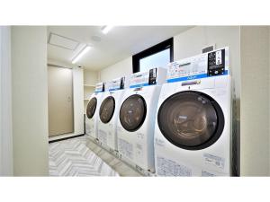 - une rangée de lave-linge blancs dans une buanderie dans l'établissement Y's Inn Naha Oroku Ekimae - Vacation STAY 25852v, à Naha