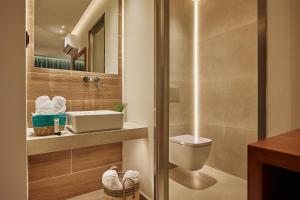 bagno con servizi igienici, lavandino e specchio di Letsos Hotel a Alykes