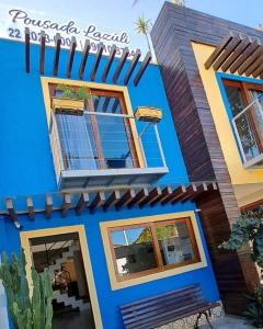 a blue building with windows and a balcony at Pousada Lazúli in Macaé