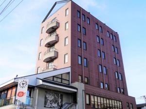 水戸市にあるArC LIFESTYLE SPACE & HOTEL - Vacation STAY 73238vの赤い建物(バルコニー付)