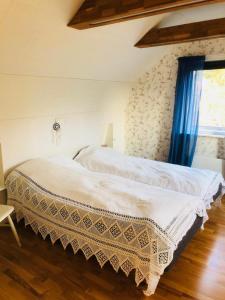 - une chambre avec un lit blanc et un rideau bleu dans l'établissement Lovely holiday house by a beautiful lake!, à Svenshögen