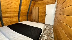Kartal Yuvası Tatil Köyü في طرابزون: غرفة نوم بسرير في غرفة خشبية