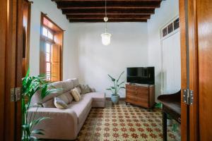 ein Wohnzimmer mit einem Sofa und einem TV in der Unterkunft CASA EMBLEMÁTICA MARUCA y LELI in Los Silos