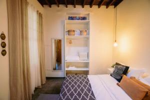 a bedroom with a bed and a shelf with vases at CASA EMBLEMÁTICA MARUCA y LELI in Los Silos