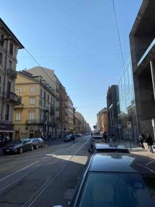 um carro a descer uma rua da cidade com edifícios em A Due Passi dal Centro em Turim