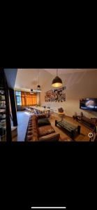 uma sala de estar com um sofá e uma mesa em LE LOFT Spa balneo em Grisolles