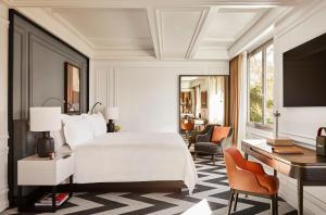 a bedroom with a bed and a desk and a computer at Rosewood Villa Magna in Madrid