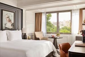 a hotel room with a bed and a desk and a window at Rosewood Villa Magna in Madrid