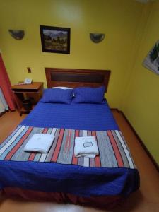 Hostal Remember في تيموكو: غرفة نوم عليها سرير وفوط