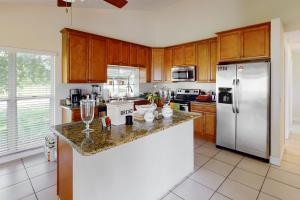 a kitchen with wooden cabinets and a stainless steel refrigerator at Glenwood Hideaway in Port Saint Lucie