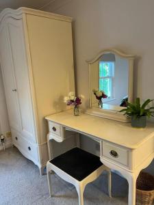a bathroom with a white vanity with a large mirror at Chic 2 bedroom cottage in Willingham
