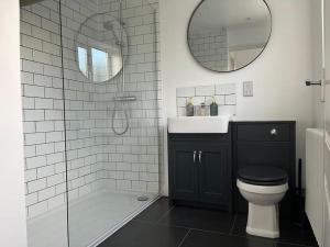 een badkamer met een toilet, een wastafel en een spiegel bij Chic 2 bedroom cottage in Willingham