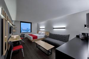 Habitación de hotel con cama y sofá en City Express by Marriott CDMX Tlalpan en Ciudad de México