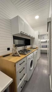 a kitchen with white cabinets and a washer and dryer at Tiny House Sitesi in Alanya