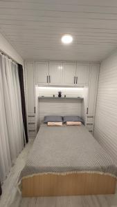 a bed in a small room with white cabinets at Tiny House Sitesi in Alanya