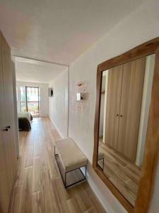 einen Flur mit einem Spiegel und einem Hocker in einem Zimmer in der Unterkunft Aix-les Bains in Aix-les-Bains