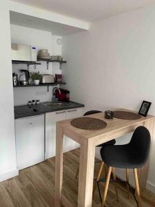 uma pequena cozinha com uma mesa de madeira e cadeiras em Aix-les Bains em Aix-les-Bains
