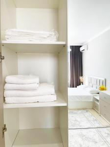 a white closet with white towels on shelves at Apart Astana, Комплекс Парасат, 279, рядом с Ботаническим садом in Astana