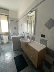 uma casa de banho branca com um lavatório e um espelho em SANT'ANNA SWEET HOME AI CONFINI DELLE LANGHE em Narzole
