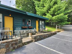 a blue house with a yellow door and a parking lot at Adirondack Diamond Point Lodge in Lake George