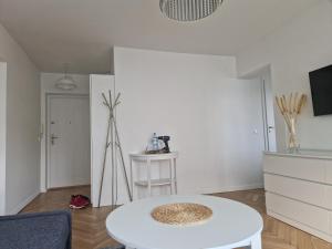 a living room with a white table in a room at Apartament Czemunie in Gdynia