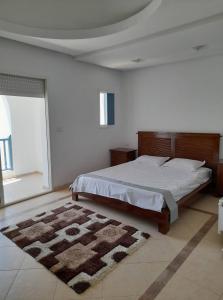 a bedroom with a large bed and a rug at Villa "LAGUNA" à 500 m de la plage - DJERBA in Houmt Souk