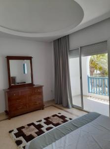 um quarto com uma cama, uma cómoda e um espelho em Villa "LAGUNA" à 500 m de la plage - DJERBA em Houmt Souk