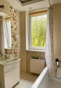 a bathroom with a sink and a window and a shower at Pokoje Slawin in Lublin