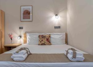 1 dormitorio con 1 cama con toallas en Fragkos Doukas Rooms en Kamariotissa