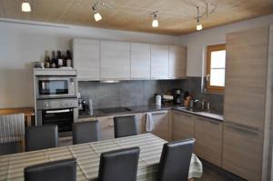 a kitchen with a table and some chairs in it at Family friendly appt on the slopes in Les Crosets