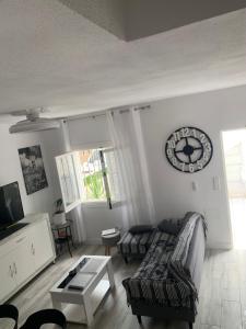 a living room with a couch and a clock on the wall at Casa de la playa in Torrevieja