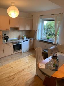 a kitchen and living room with a table and a window at Apartment close to the center + free parking in Oldenburg +6 photos
